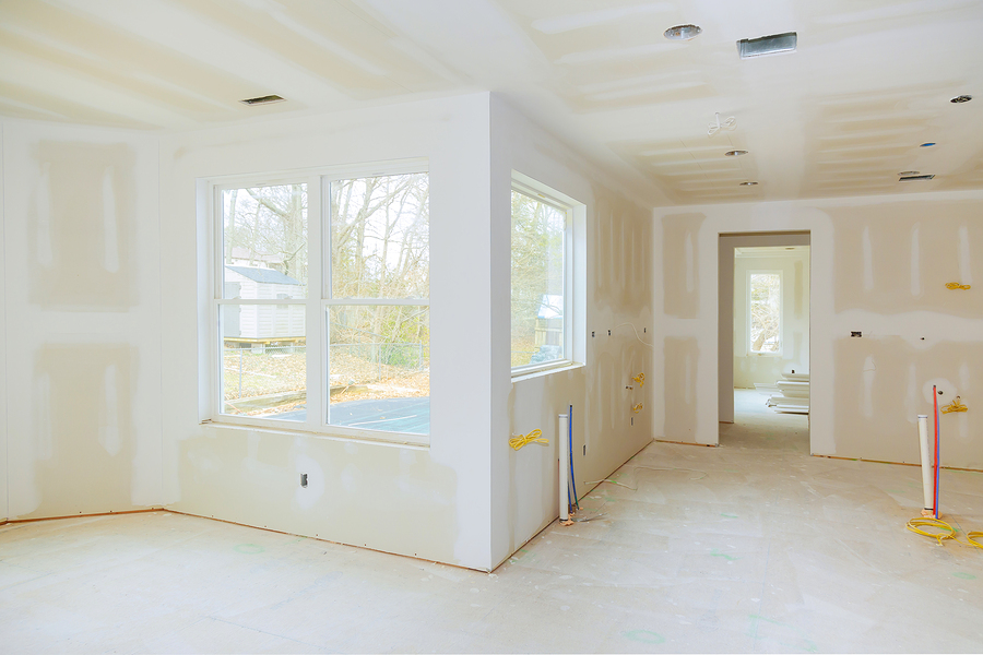 Interior construction of housing project with drywall installed and patched without painting applied interior with drywall installation and construction work in progress