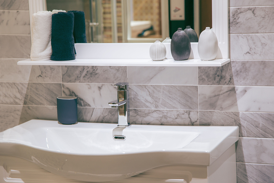 Updated bathroom sink and mirror with modern tile backsplash.