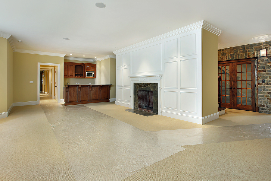 Basement renovation with a fireplace and a bar.