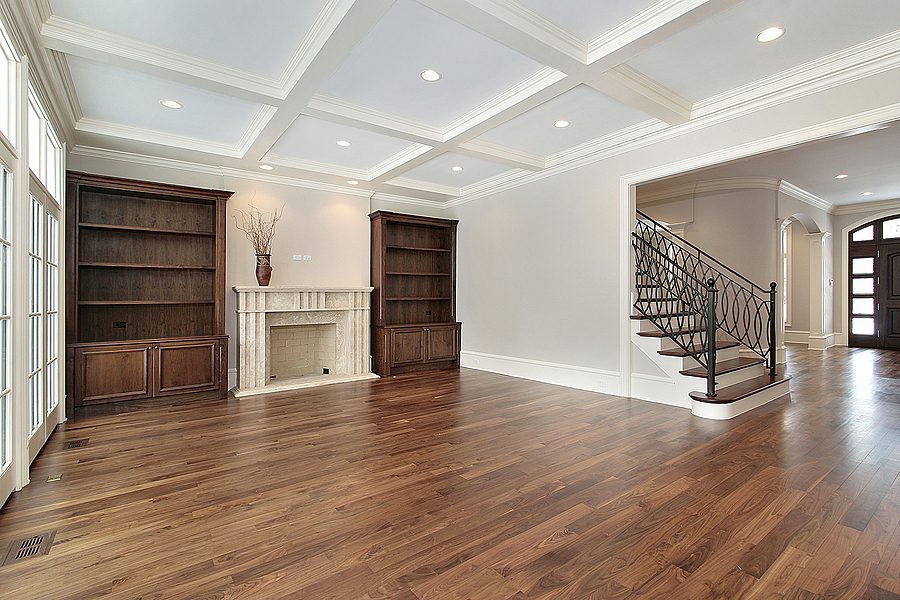 Living room area of a home with white walls and ceilings and new cherry hardwood flooring.
