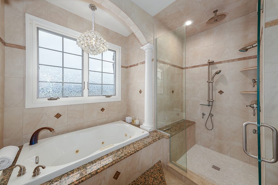 custom bathroom design with both a shower and a bath tub and brown and tan tiling
