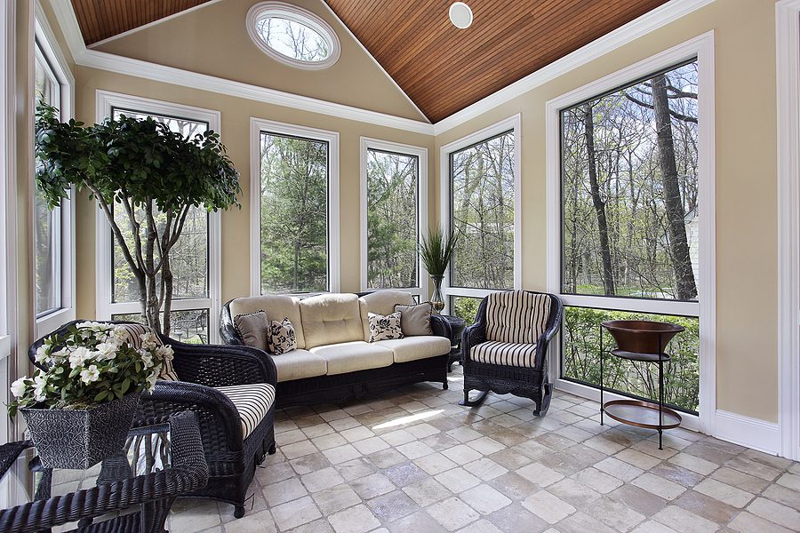 sunroom in beautiful home with many windows and black wicker furniture 